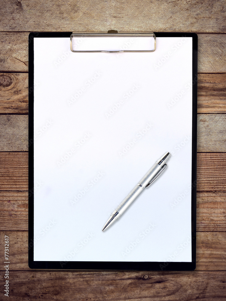 white paper clipboard on wood background with pen white paper clipboard on wood background with pen