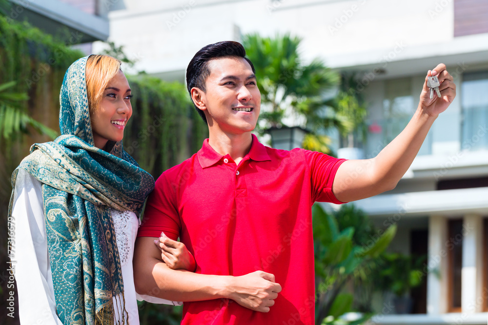 Naklejka premium Asian Muslim couple moving into house