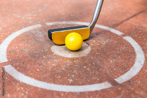 Minigolf Golfschläger mit Ball beim Abschlag photo