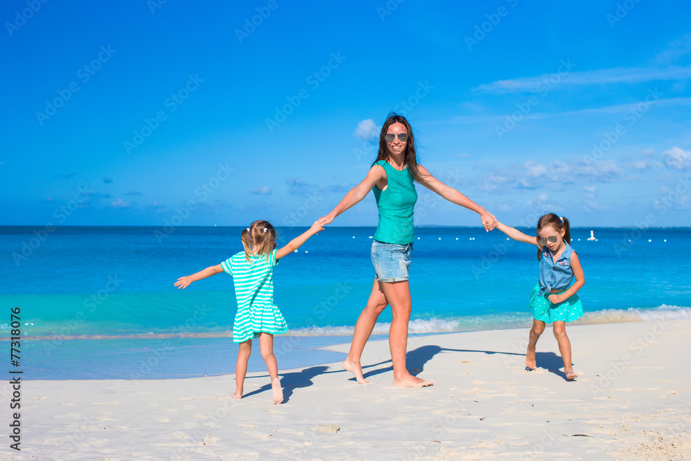 Young happy mother and little girl having fun during beach