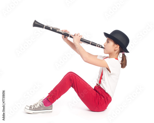 little girl playing clarinet on a white background