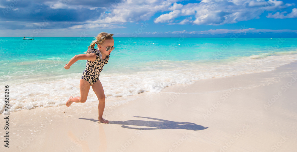 Adorable little girl on white beach during tropical vacation Adorable little girl on white beach during tropical vacation