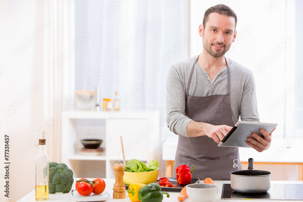 Young attractive man cooking in a kitchen Young attractive man cooking in a kitchen
