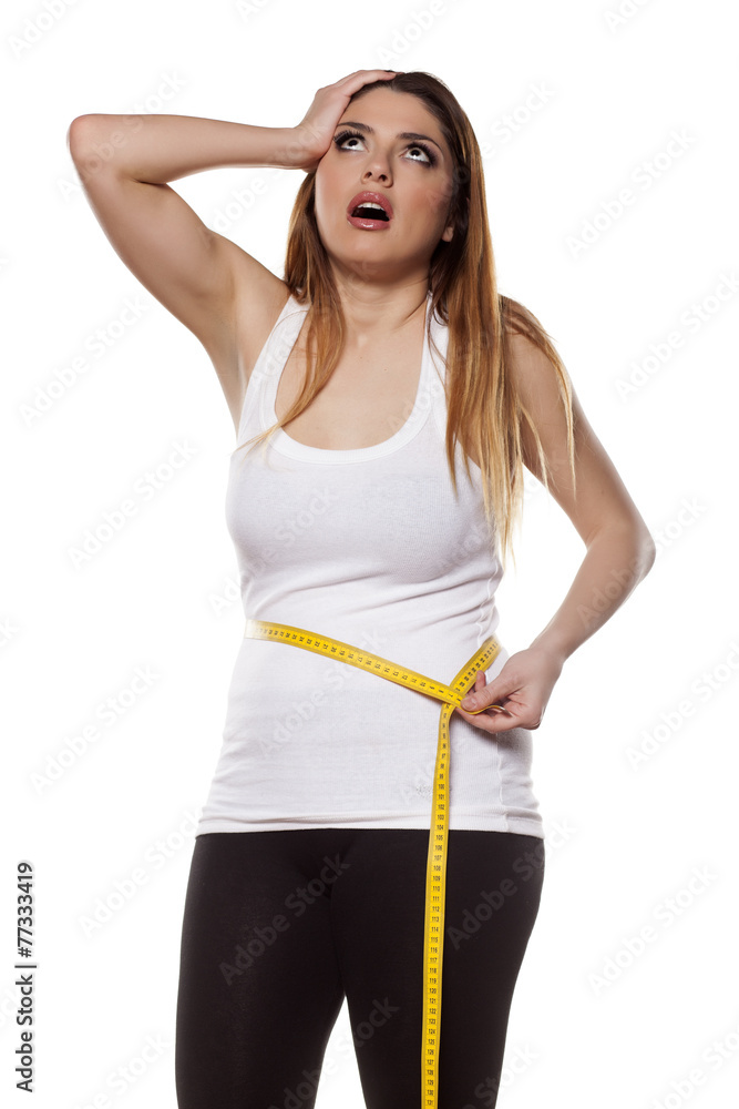 young woman is disappointed by the extent of her waist young woman is disappointed by the extent of her waist