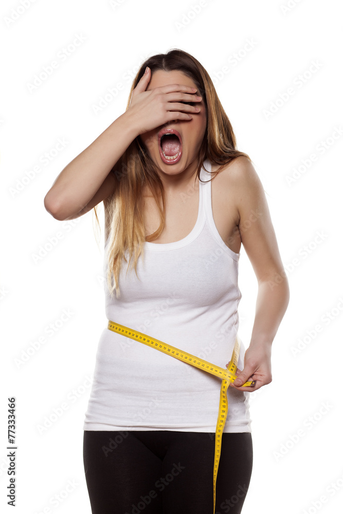 young woman is shocked by the scope of her waist young woman is shocked by the scope of her waist