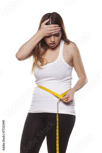 фотографія young woman is disappointed by the extent of her waist