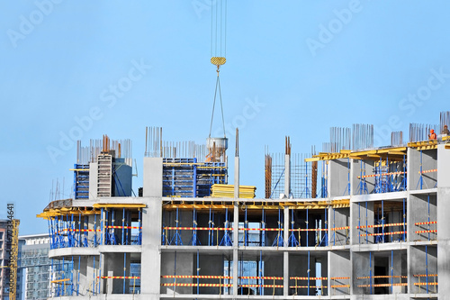 Wallpaper Mural Crane lifting concrete mixer container against blue sky Torontodigital.ca
