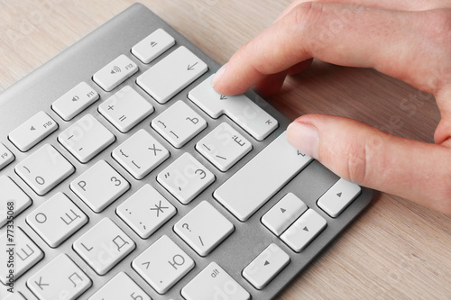 Female hand with keyboard on wooden desktop background