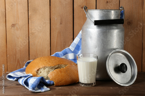 Retro can for milk with fresh bread and glass of milk