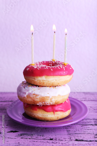 Delicious donuts with icing and birthday candles
