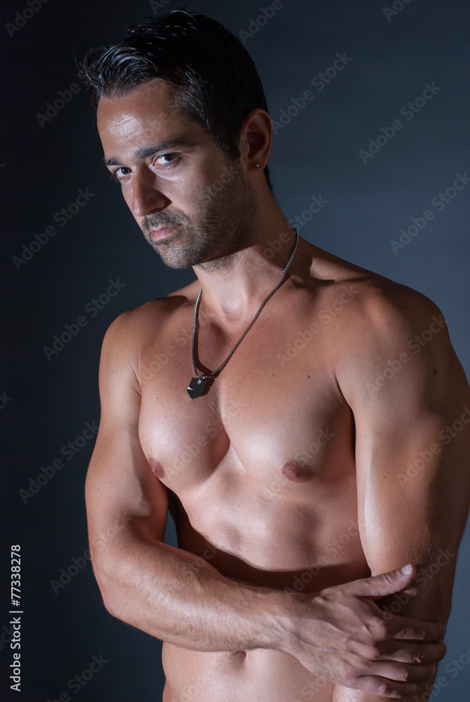 Fototapeta premium Muscle sexy man posing on bark background, showing his muscles