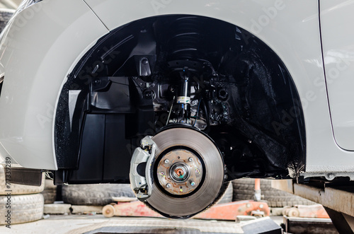 Obraz na płótnie Front disc brake on car in process of new tyre replacement. The