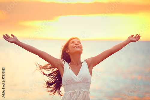 Free happy woman praising freedom at beach sunset