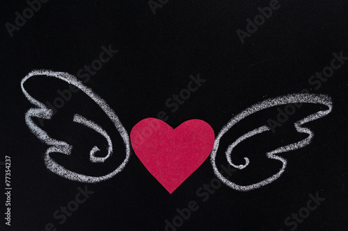 paper heart with pictured chalk wings on black background