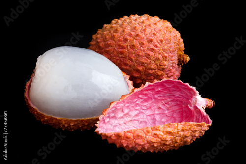 Single litchi with skin removed and flesh. On black.