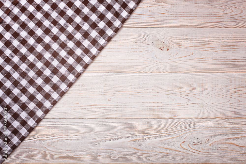 Top view of checkered tablecloth on white wooden table. Top view of checkered tablecloth on white wooden table.