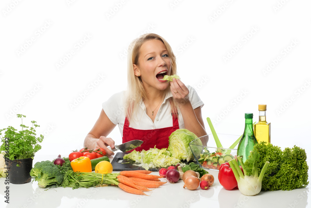 Frau schneidet einen Salatkopf zu und probiert Frau schneidet einen Salatkopf zu und probiert
