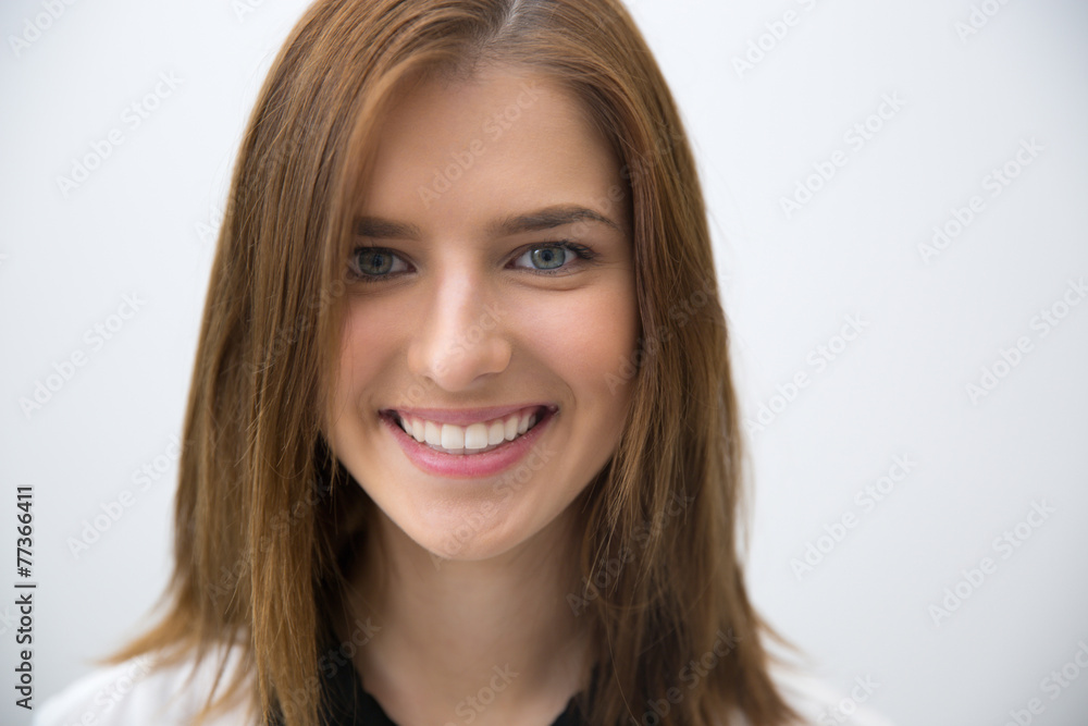 Closeup portrait of a young smiling woman over gray background Closeup portrait of a young smiling woman over gray background