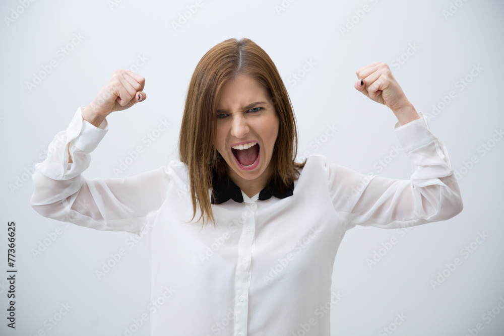 Excited young woman celebrating success over gray background Excited young woman celebrating success over gray background