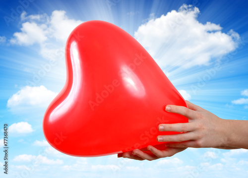 Balloon in the shape heart in hands © vencav