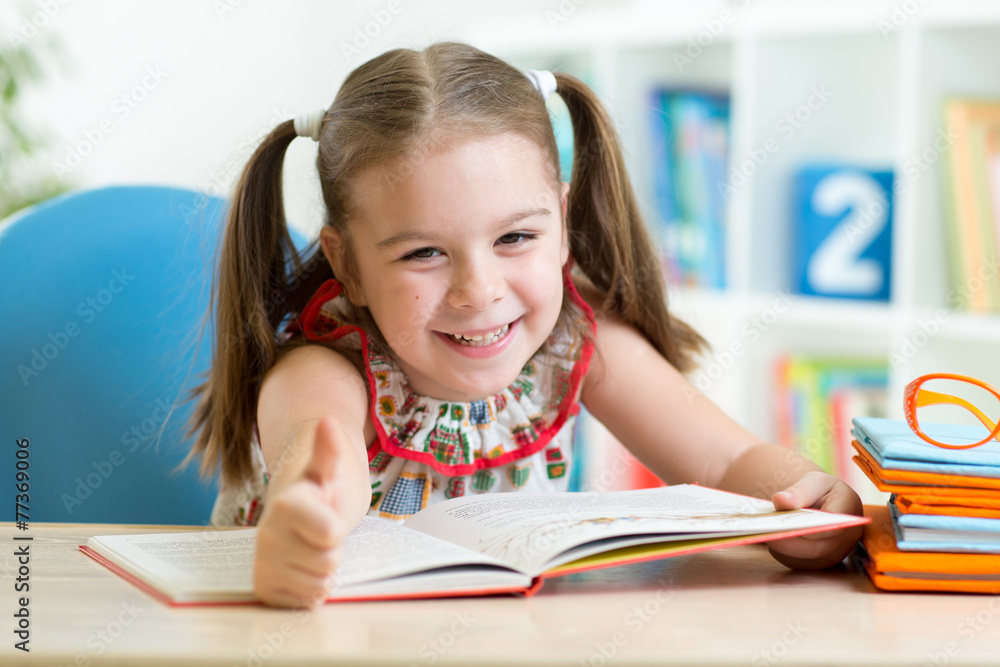 child girl reading story from big book in nursery child girl reading story from big book in nursery