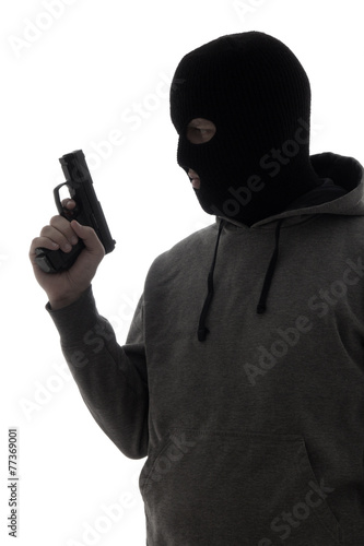 dark silhouette of criminal man in mask holding gun isolated on