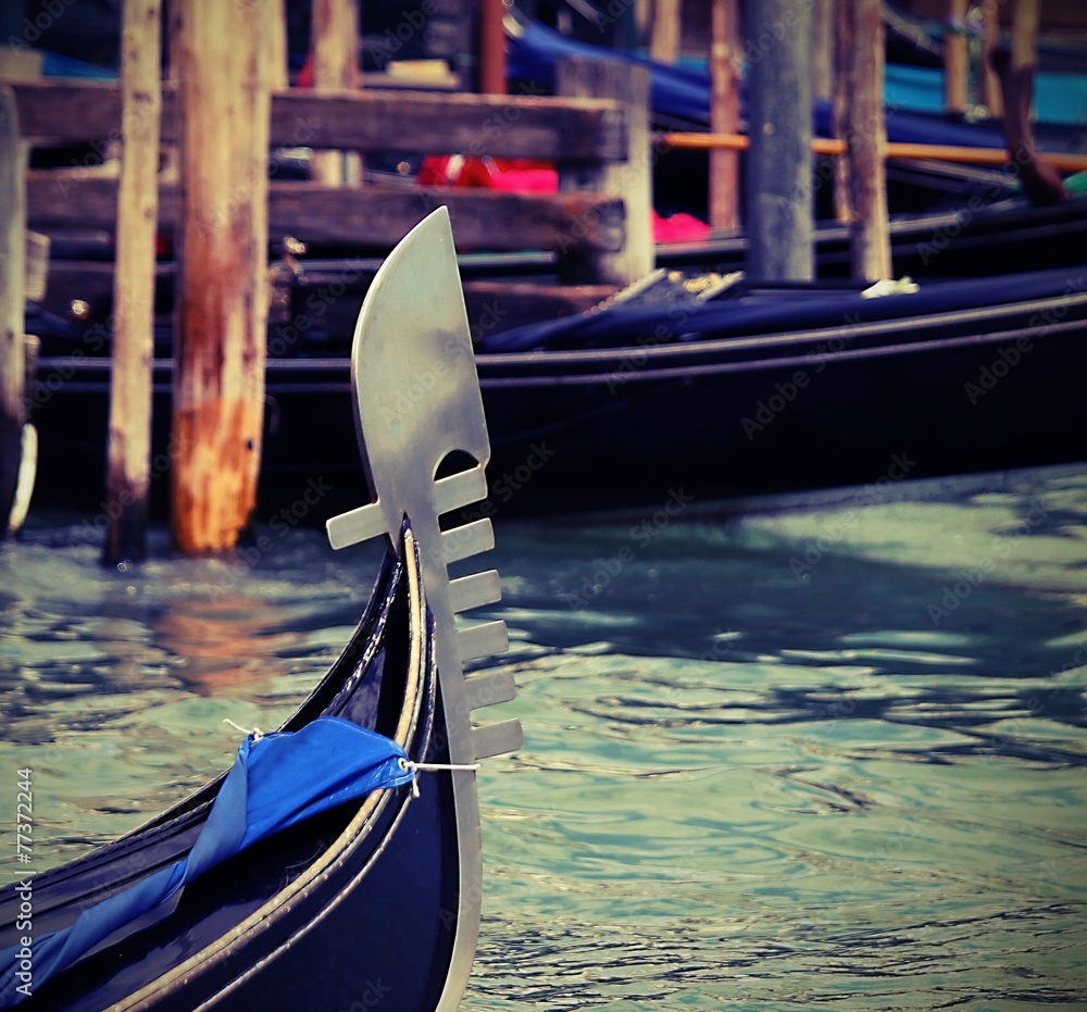 famous bow gondola in Venice  in the lagoon with other boats