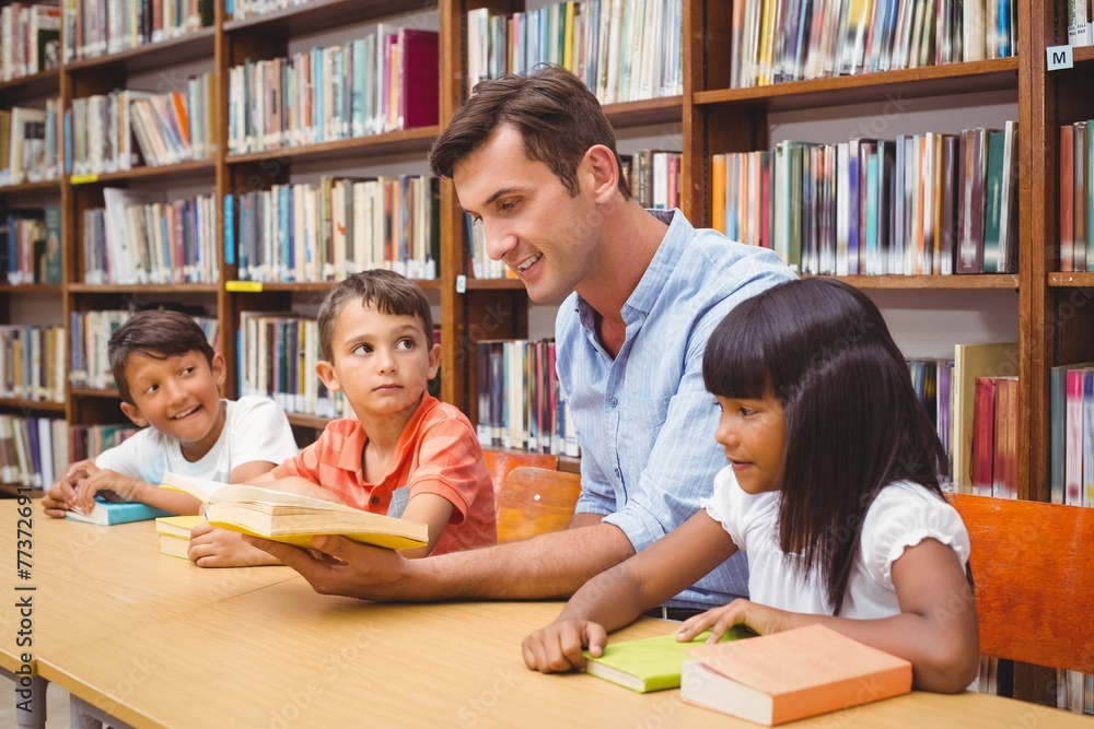 Cute pupils and teacher reading in library Cute pupils and teacher reading in library