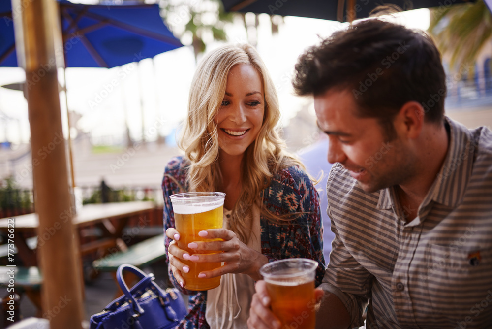 Naklejka premium romantic couple drinking beer at outdoor restaurant