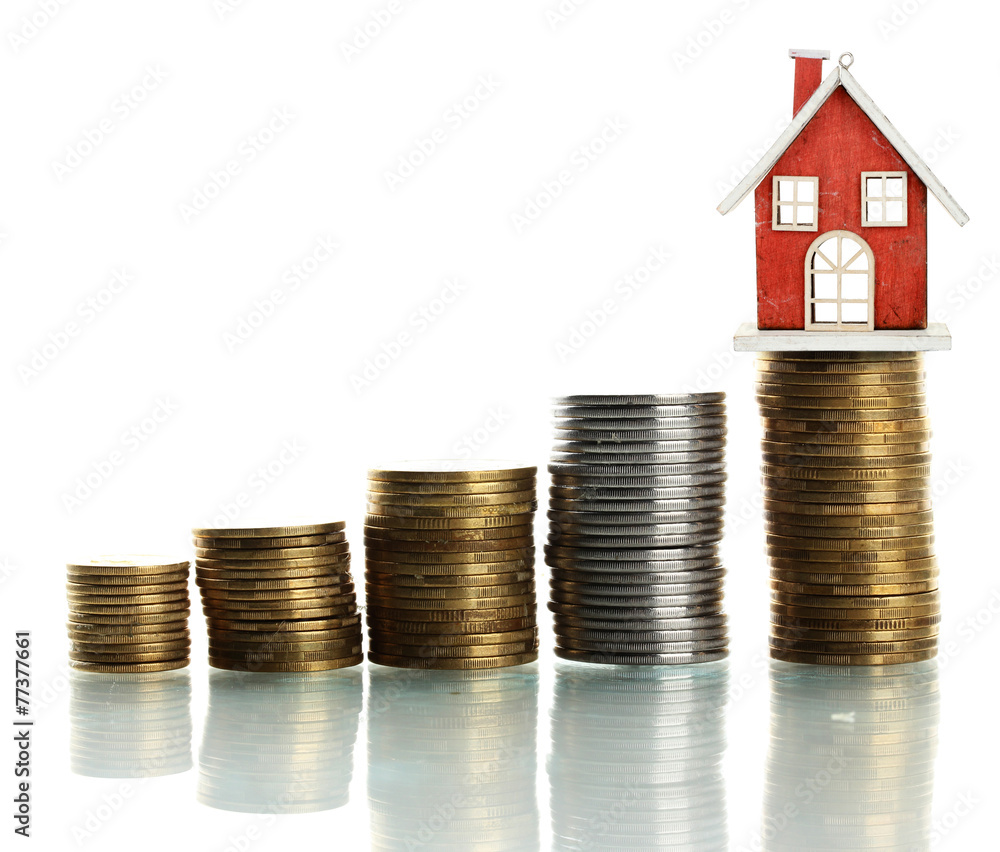 Small house standing on stack of coins isolated on white Small house standing on stack of coins isolated on white