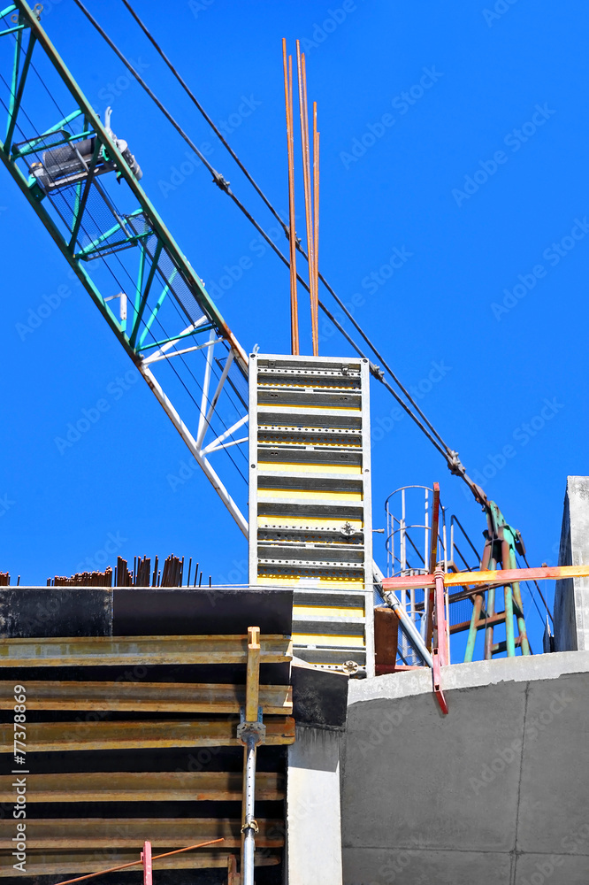 Naklejka premium Crane and building construction site against blue sky