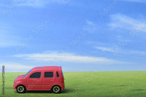 青空と草原と赤いワゴン車