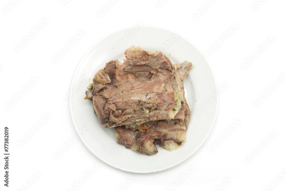 Bone with meat on a plate. Photo.