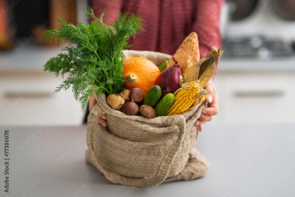 Closeup on housewife showing fresh vegetables in shopping bag