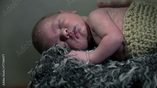 Tilt shot of baby dressed in knitwear while sleeping comfortably photo