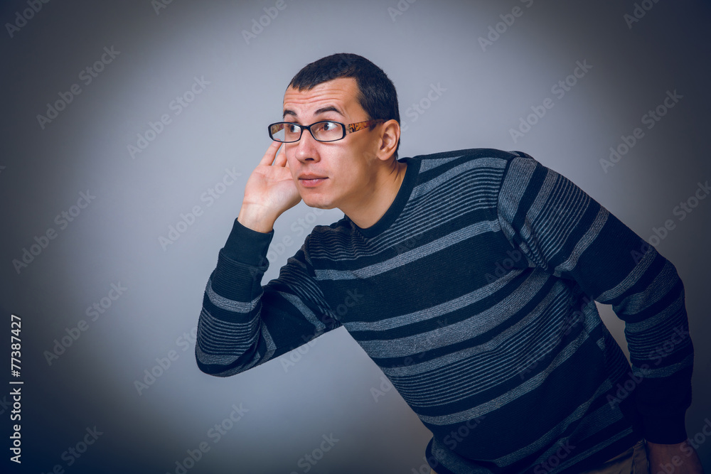 male of European appearance brunet put his hand to ear eaves male of European appearance brunet put his hand to ear eaves