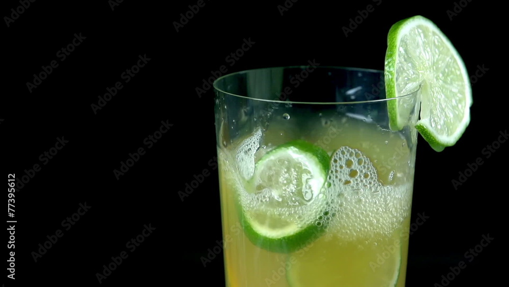 Slices of citrus fruit fall into glass full of juice in slow motion Slices of citrus fruit fall into glass full of juice in slow motion