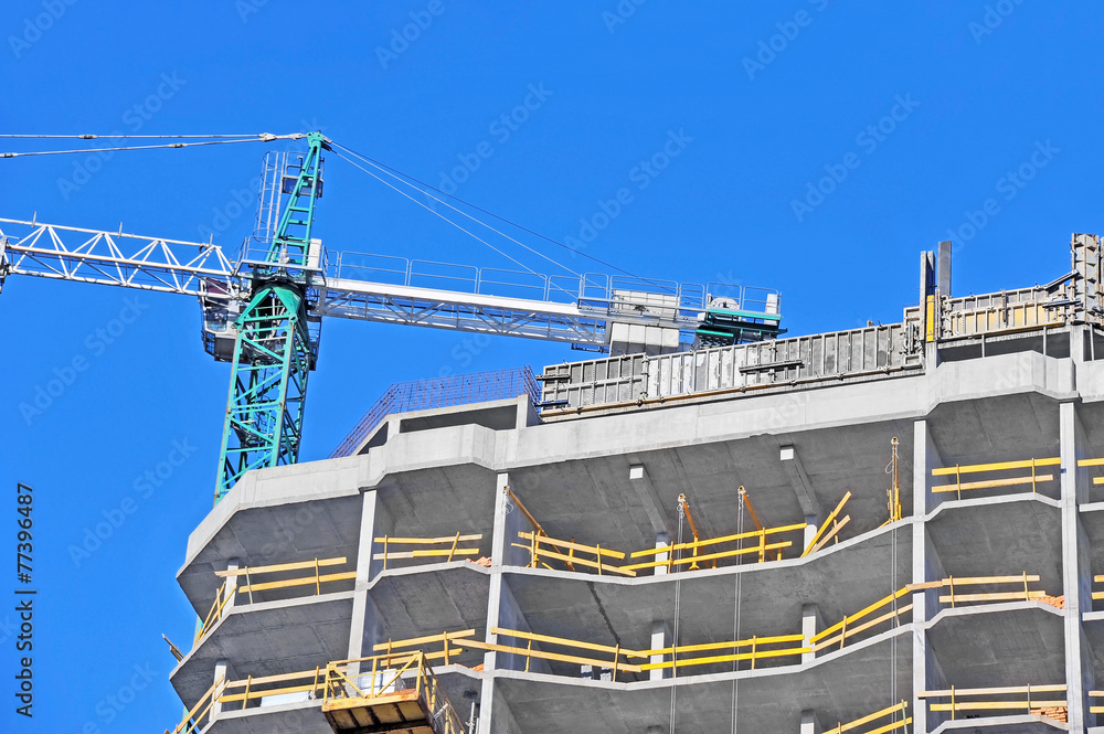 Crane and building construction site against blue sky