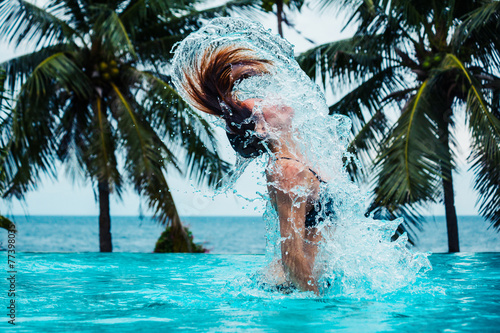 Sexy woman doing hairflip in swimming pool