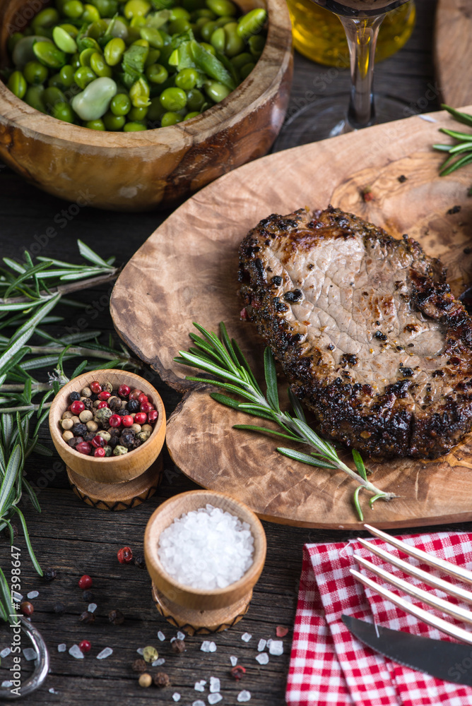 Grilled medium rare beef steak with herbs on rustic table Grilled medium rare beef steak with herbs on rustic table