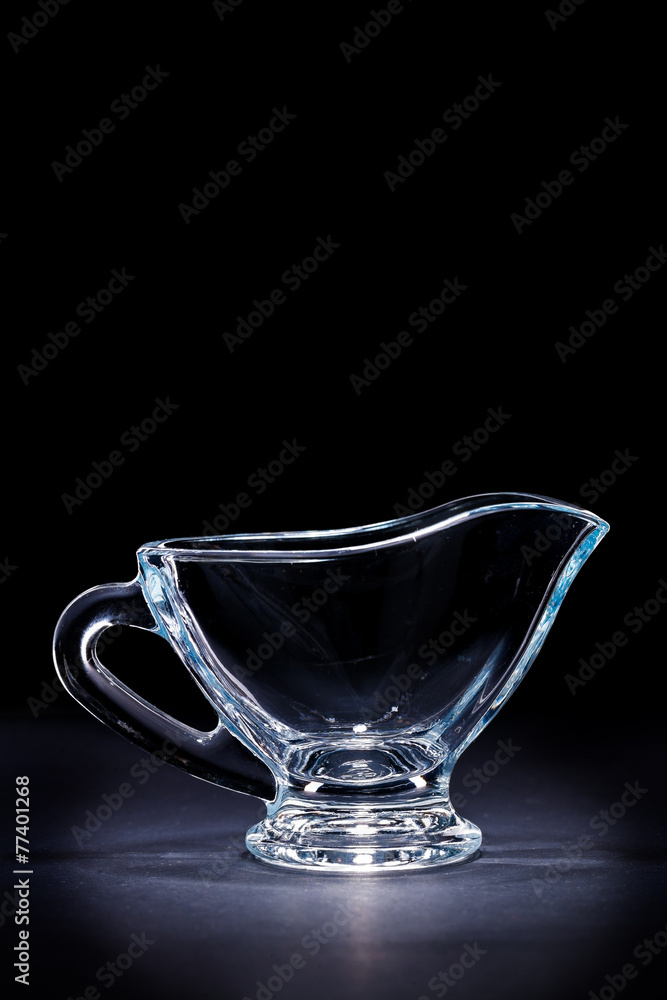 glass transparent gravy boat on black background glass transparent gravy boat on black background