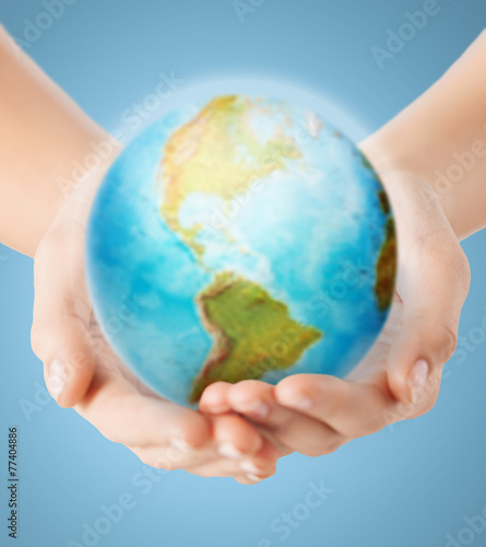 close up of human hands with earth globe