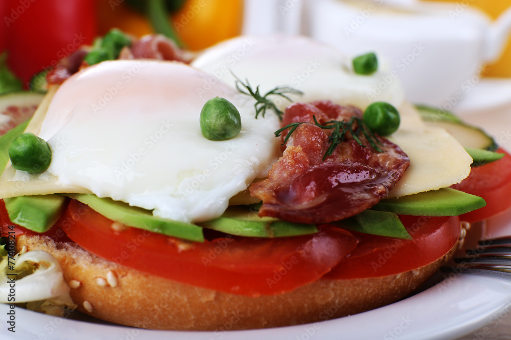 Sandwich with poached eggs, bacon and vegetables