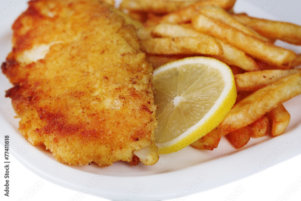 Breaded fried fish fillet and potatoes with sliced lemon Breaded fried fish fillet and potatoes with sliced lemon
