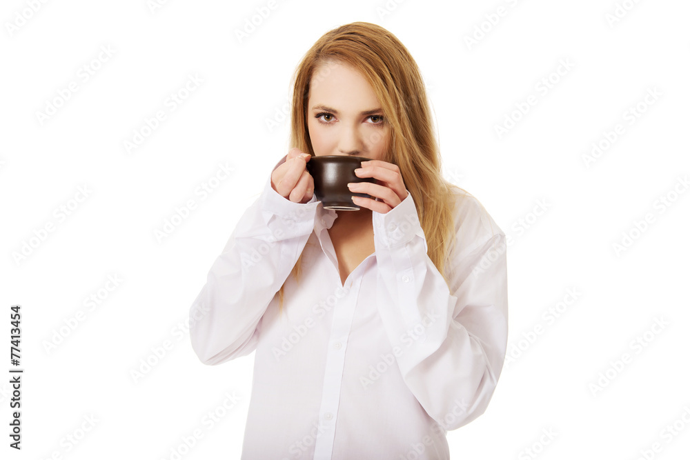 Woman in long sleeve shirt drinking coffee. Woman in long sleeve shirt drinking coffee.