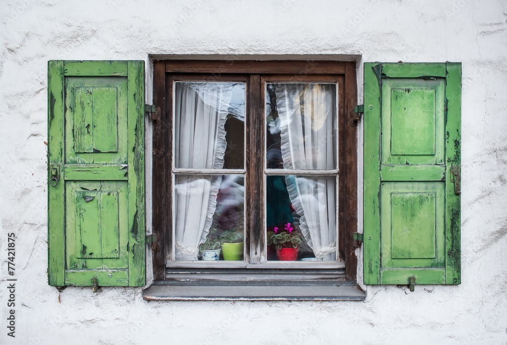 Authentic window with green wooden shuttters in a small town of Authentic window with green wooden shuttters in a small town of