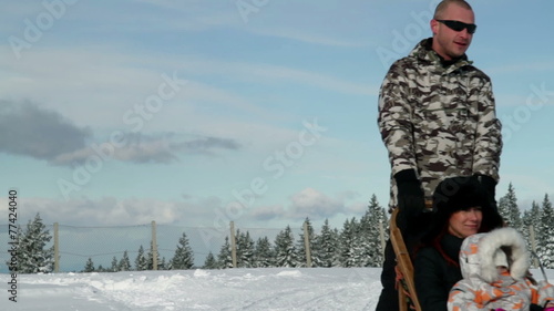 a mother and her daughter while driving with sledge pulled by dogs and  enjoying in the idyllic soroundings photo