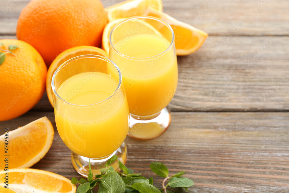 Glass of orange juice and slices on wooden table background Glass of orange juice and slices on wooden table background