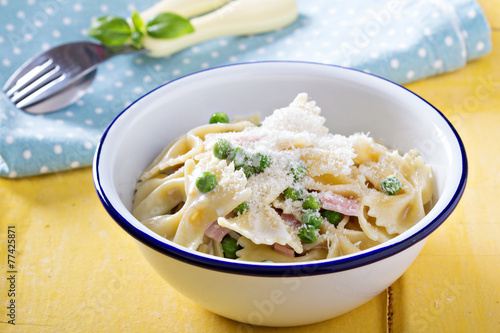 Bow ties pasta with ham and green peas