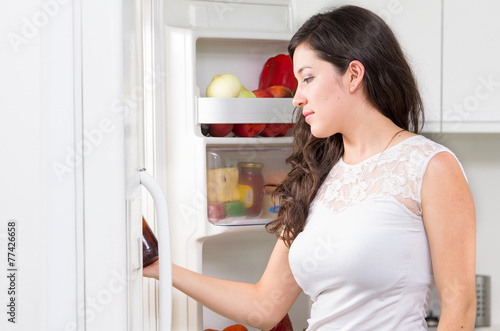 young beautiful woman searching for food in the fridge
